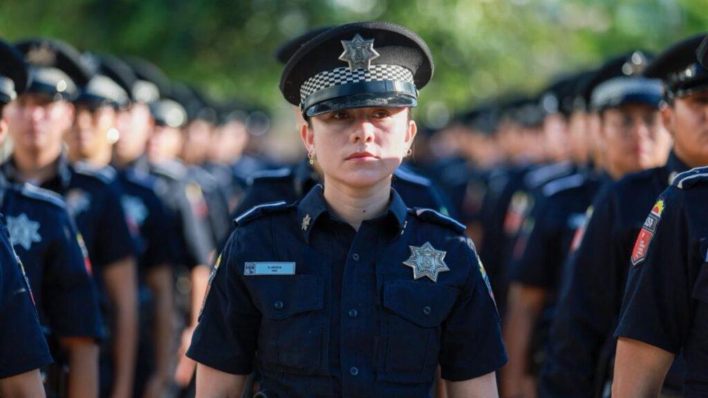 mujer-policia-san-pedro-economia - CRONICAS REGIAS Female police officer in uniform standing at attention in front of a line of fellow officers blurred in the background.