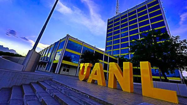 uanl-ciclo-escolar - CRONICAS REGIAS Exterior view of a modern university building with large yellow 'UANL' letters on the steps